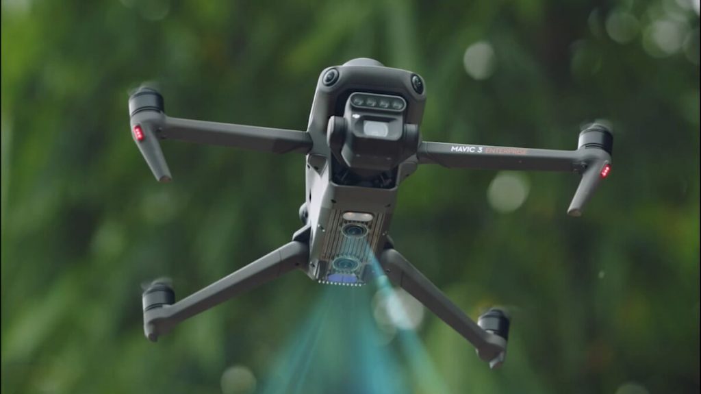 DJI Multispektral-Drohne bei der Feldanalyse über einem Getreidefeld“. Bildunterschrift: „Multispektralanalyse in der Landwirtschaft per Drohne: Die DJI Mavic 3M erfasst während des Überflugs detaillierte Pflanzendaten.